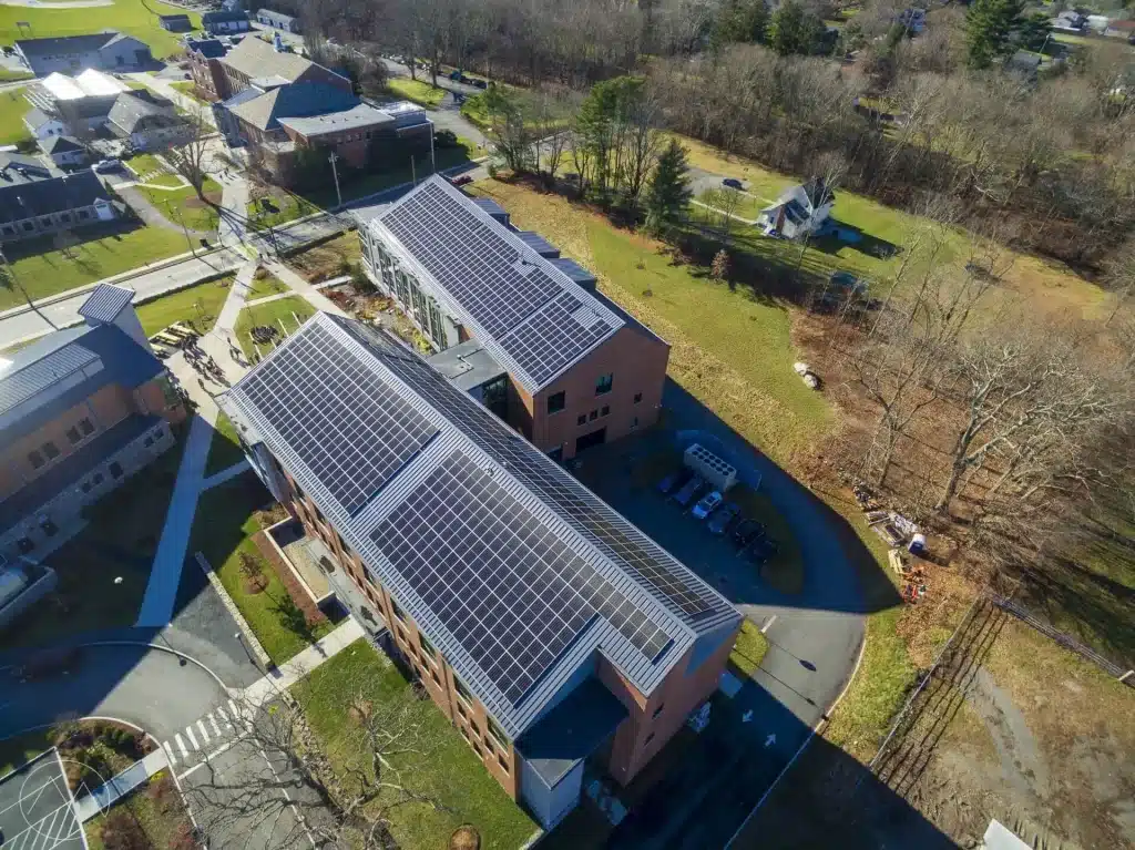 Aerial view of a commercial building in Bridgewater, MA, featuring solar panels on the roof, surrounded by green spaces and parking areas, showcasing BD Electrical Services' solar power installation projects.
