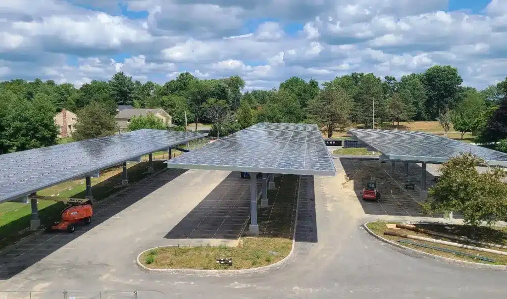 Framingham, MA solar canopy installation featuring multiple solar panels on elevated structures in a commercial setting, showcasing clean energy solutions by BD Electrical Services.