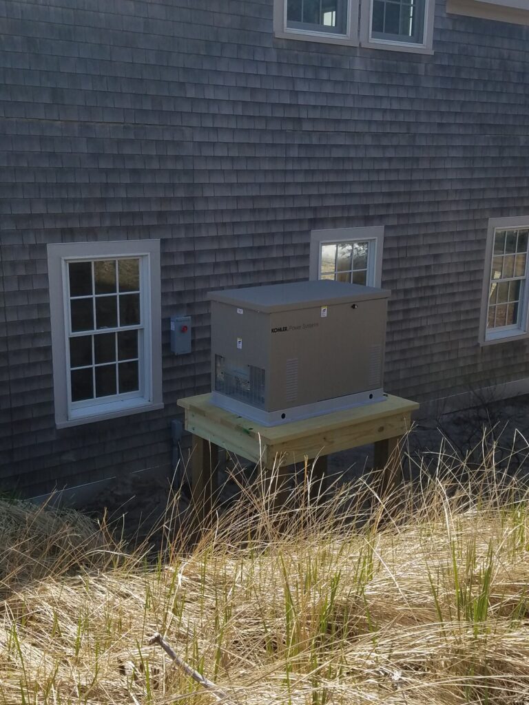 Kohler standby generator on a raised platform beside a residential home